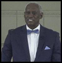 A person in a suit and bow tie
Description automatically generated